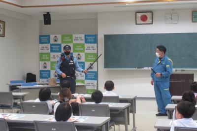 警察の装備品について実際に見せて説明している様子
