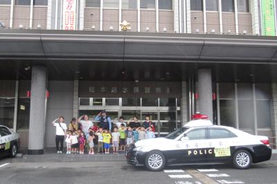 警察署の前でパトカーと一緒に記念撮影をした様子