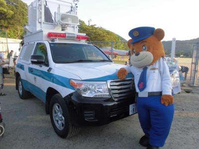 県警マスコット「ゆっぴー」と警察車両の写真
